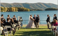 a wedding ceremony at a lake with mountains in the background